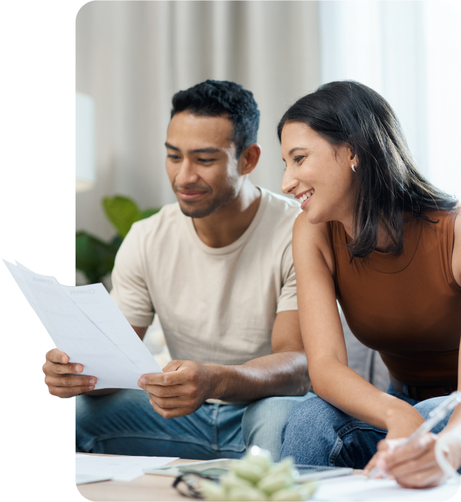 Smiling couple reviewing documents at home, planning their financial future with Guardian Financial Planning’s retirement planning services, focused on long-term savings, investment strategies, and retirement readiness.