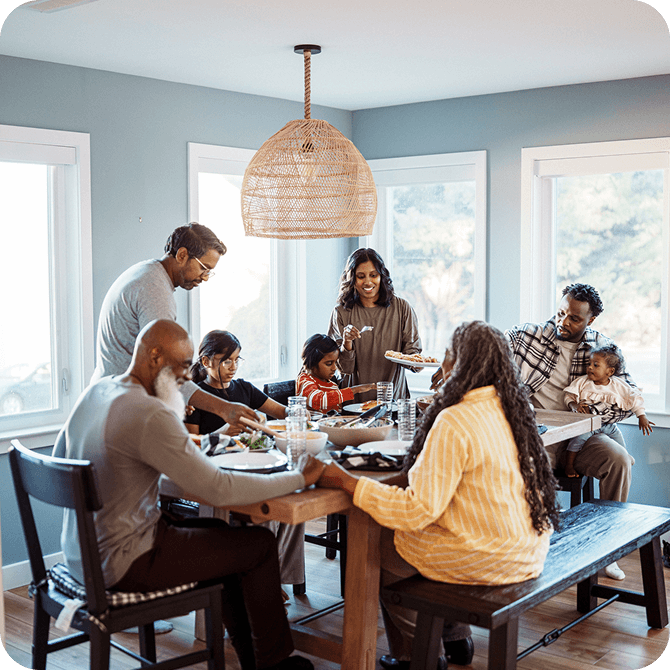 Multi-generational family gathered around the table, representing Guardian CU’s life insurance protection for loved ones