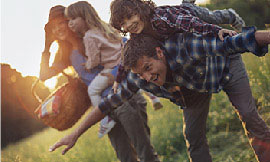 Young family playing in a field at dusk.