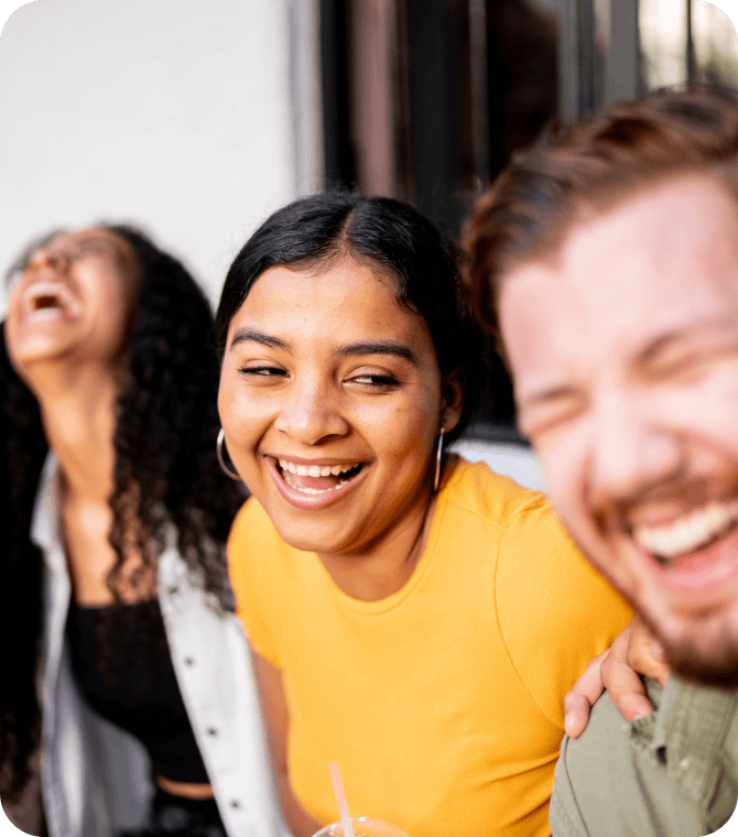 Group of young adults laughing together, representing community, connection, and financial well-being