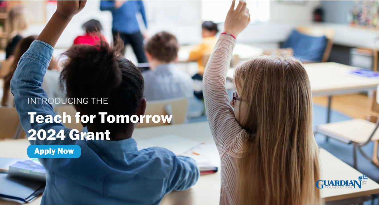 Guardian Teach for Tomorrow Grant. Children raising hands in classroom.