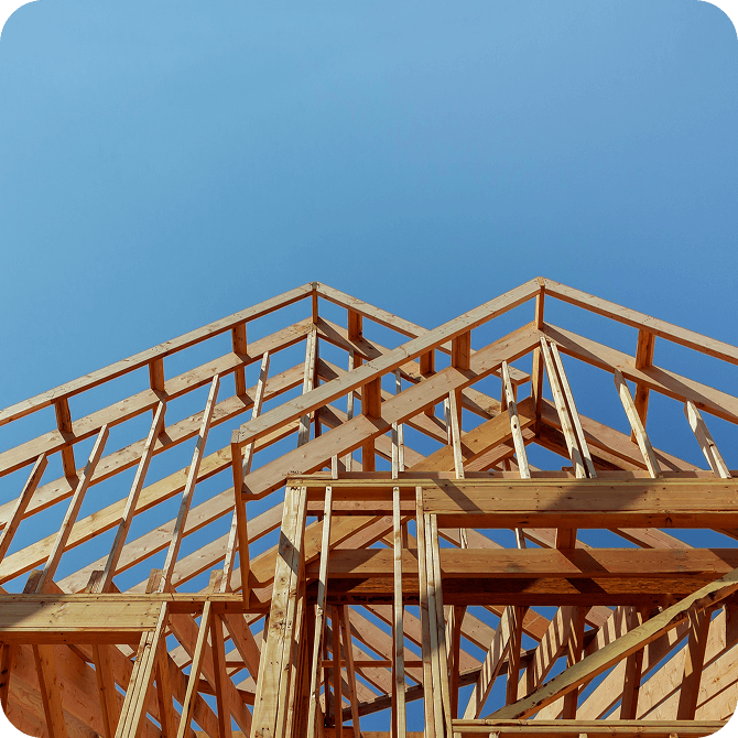 Framing of a new home under clear blue sky, representing construction financing through Guardian CU’s Home Loans