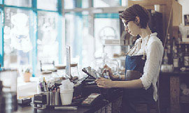 Young business person in front of cash register.