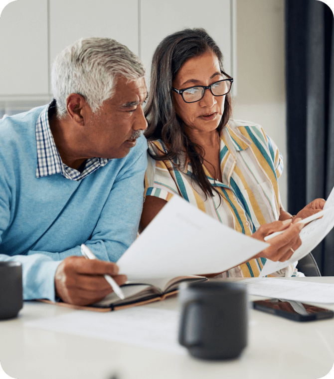 Mature couple reviewing financial documents together, planning with Guardian Credit Union support